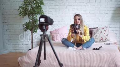 搞笑女博主录制视频.. 女孩美容博主坐在床上，给你的博客写视频。